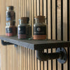 Small presentation shelf in store selling spices wall mounted with strong supports made from water pipes