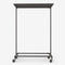 Clothes rack in dark pipes with wheels and wooden shelf in dark pine