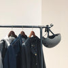 Clothes rail made from dark modern water pipes in industrial design for jackets with hooks for helmet