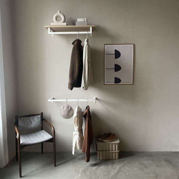 Modern entrance design with clothing rails made from white iron pipes for jackets and coats with shelf on top