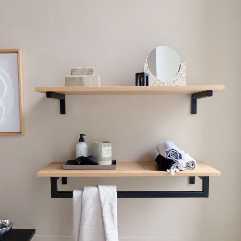 Modern interior design for bathroom with wall mounted floating shelves made from oak and black metal supports