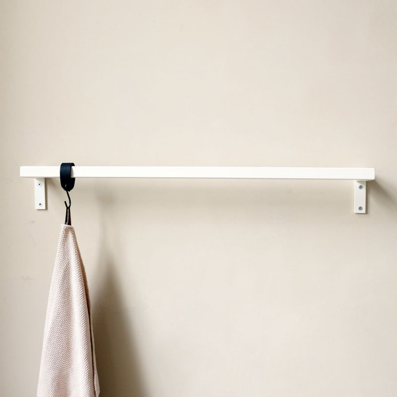 Modern simplistic wall mounted clothing rail made from iron pipes powder coated in white