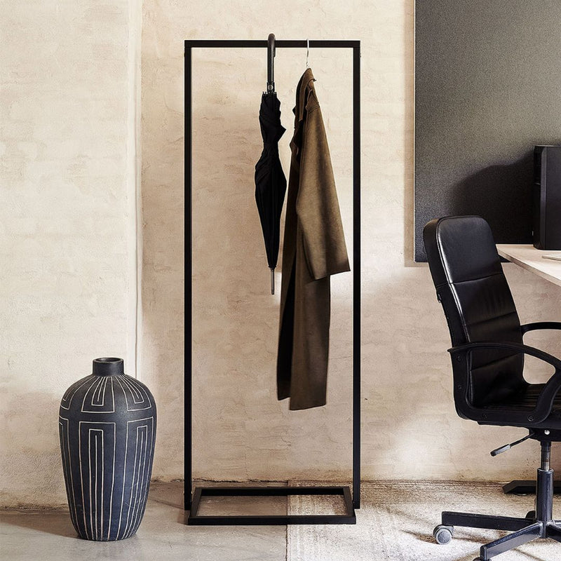 Free standing rack in the office for jackets modern slick design black iron pipes