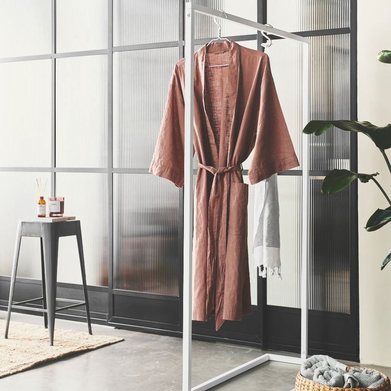 Free standing clothes rack as practical wardrobe in bathroom for towels and bathrobe