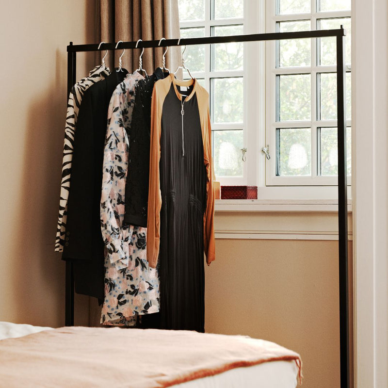 Free standing clothes rack made from black metal pipes open wardrobe for hotel room