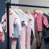 Clothing rail in black metal to display clothing for children in store simplistic design