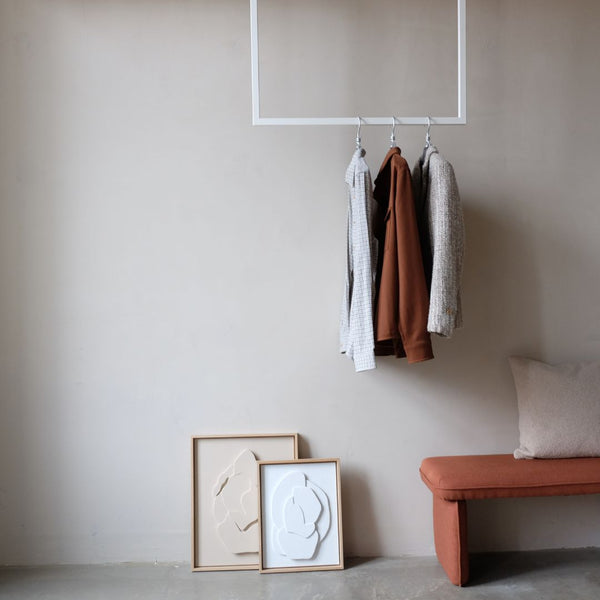 Ceiling mounted clothes rail made from white iron pipes square geometrical design