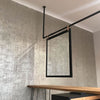 Ceiling mounted dark iron rail used to hang big mirror as room separator modern simple design