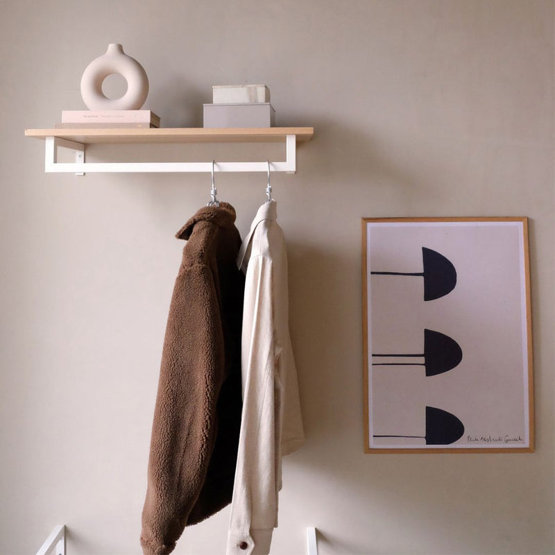 Wall mounted shelf made from white painted clothing rail with shelf on top for jackets and decorations