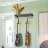 wall mounted shelf in minimalistic design with black rail to hang guitars and shelf on top