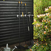 practical iron hooks made from silver water pipes to organize the garden tools behind the shed