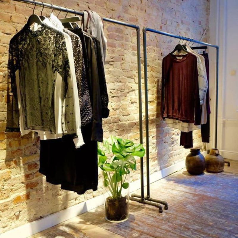 free standing display racks in clothing store made from industrial dark water pipes