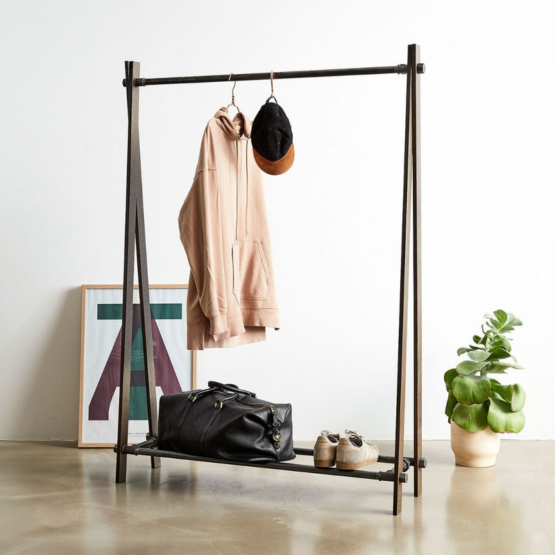 Free standing clothes rack made from smoked oak supports with dark water pipes in scandi style