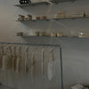 Free standing rack made from silver water pipes used for hanging tote bags with hangers in pottery studio