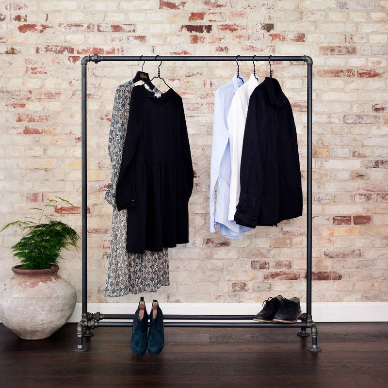 Free standing rack in industrial design made from dark water pipes for shoes and jackets