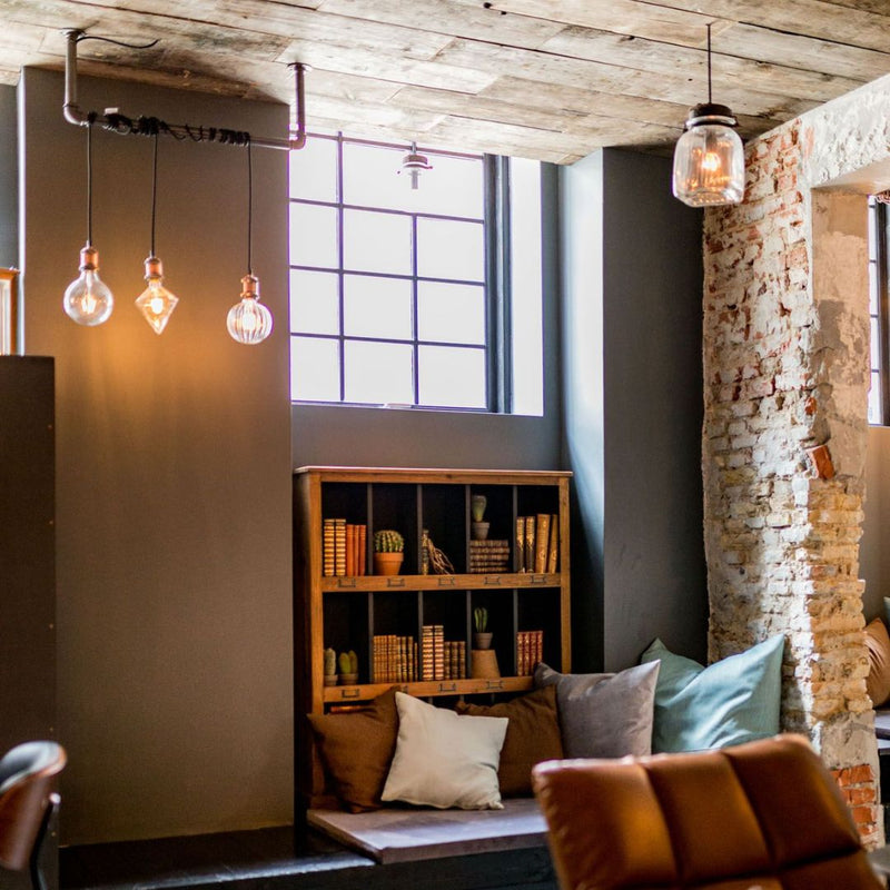 cozy corner with modern light fixtures made from dark iron pipes to attach light blubs to