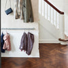 Simple clothes rail attached to wall for children´s jackets and rain pants in silver water pipes