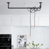 Ceiling mounted U shape made from iron pipes used to attach light blubs above kitchen counter