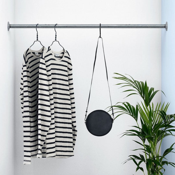 Clothes rail made from strong iron pipes attached between two walls for maximum space