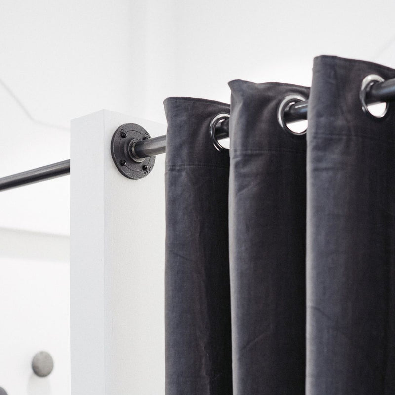 Modern curtain rail made from dark water pipes between two walls to create changing room