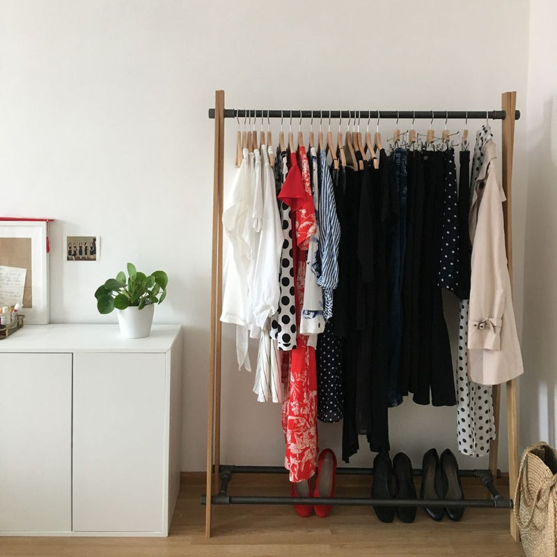 Free standing clothes rack made from dark iron pipes and massiv oak supports nordic design