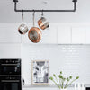 practical storage for pots and pans in the kitchen with ceiling mounted dark iron rails to hang pots